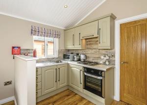 a kitchen with white cabinets and a stove top oven at Crake Valley in Torver