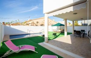 a patio with lawn chairs and a swimming pool at 3 Bedroom Amazing Home In El Mojón in El Mojón +26 photos