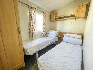 a small room with two beds and a window at Superb 6 Berth Caravan At Sunnydale Holiday Park Ref 35079a in Louth