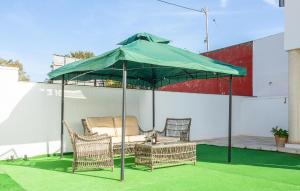 a green umbrella on top of a patio at 3 Bedroom Amazing Home In El Mojón in El Mojón