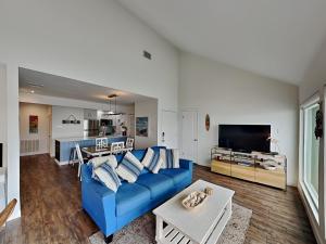 a living room with a blue couch and a kitchen at Sunset Water View in Padre Island