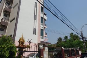 a building with a statue in front of it at ธิติกาญจน์ อพาร์ทเม้นท์ in Ban Khlong Samrong