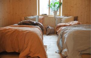 two beds sitting in a room with a window at 3 Bedroom Beautiful Home In Katrineholm in Katrineholm