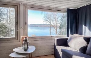 Cette chambre dispose d'un canapé et d'une grande fenêtre. dans l'établissement Lovely Home In Alingss With Lake View, à Alingsås