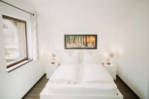 a white bedroom with a bed and a window at CABANA BERNER stațiunea Mogoșa in Baia-Sprie
