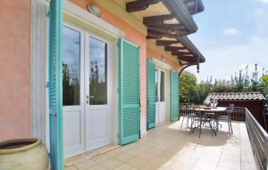 balcón con puerta, mesa y sillas en 3 Bedroom Awesome Home In Camaiore, en Camaiore