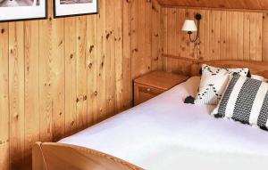 a bedroom with wooden walls and a bed with white sheets at 3 Bedroom Beautiful Home In Studzienice in Studzienice