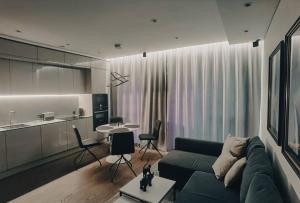 un soggiorno con divano verde e una cucina di Brand new apartment in Vilnius center. a Vilnius
