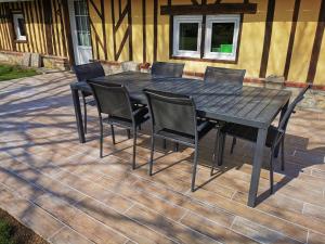 einen schwarzen Tisch und Stühle auf einer Terrasse in der Unterkunft La Bergerie in Cambremer