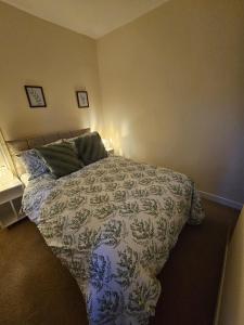 a bedroom with a bed with a blue and white comforter at Main Street Swinford! in Swinford
