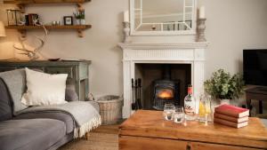 a living room with a couch and a fireplace at The Sheep Cote, Pentland Hills in Nine Mile Burn