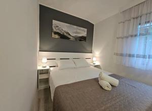 ein Schlafzimmer mit einem Bett, zwei Tischen und einem Fenster in der Unterkunft Apartmani Central in Mostar