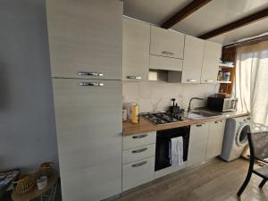 uma cozinha com armários brancos e um forno com placa de fogão em Eros OceanView Attic em Santa Cruz de Tenerife