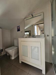 uma casa de banho com um WC, um lavatório e um espelho. em Eros OceanView Attic em Santa Cruz de Tenerife