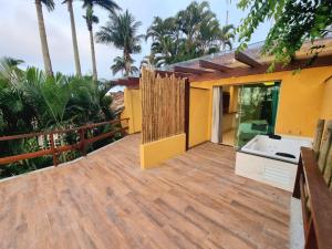 a house with a large wooden deck with a sink at Hotel Pousada Casacolina in Búzios