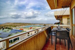 d'un balcon avec une table et des chaises et une vue. dans l'établissement Belvedere - Cozy 2bed Mellieha Seaview, à Mellieħa