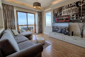 ein Wohnzimmer mit 2 Sofas und einem Flachbild-TV in der Unterkunft Belvedere - Cozy 2bed Mellieha Seaview in Mellieħa