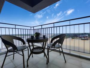 a balcony with two chairs and a table with a view at Bright Cozy Waterfront in Sibu