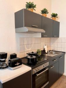 una cocina con fogones con ollas y sartenes. en Wohnung im Zentrum 1, en Magdeburgo