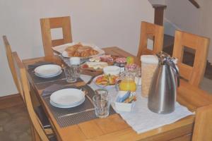 drewniany stół ze stołem z jedzeniem w obiekcie Les Bruyeres B&B w mieście Montbron