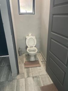 un bagno con servizi igienici bianchi e porta di OlimG Stays Budget Room1 a East London