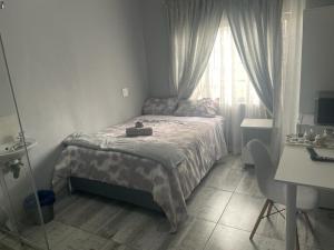 una piccola camera da letto con un letto e una finestra di OlimG Stays Budget Room1 a East London