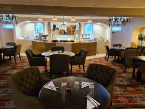 a restaurant with tables and chairs and a bar at Barons Court Hotel Walsall in Walsall