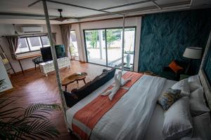 a bedroom with a large bed and a living room at La Belle Vie - Boutique Hotel Adults Only in Baan Tai