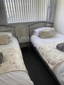 dos camas sentadas una al lado de la otra en una habitación en 44 Gower holiday village Ty Gŵyr Cosy 2 bedroom Chalet en Swansea