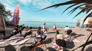 eine Gruppe von Leuten, die Yoga am Strand machen in der Unterkunft Kite Crew Kite and Surf School, Chałupy 6 Przyczepy Kempingowe in Chałupy