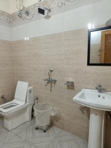 a bathroom with a toilet and a sink at Uk09 hotel & Restaurant in Mussoorie