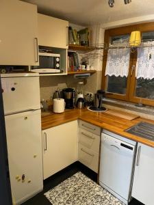cocina con armarios blancos y encimera de madera en Crissisroom, en Zell im Wiesental