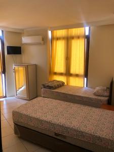 Cette chambre comprend 2 lits et une fenêtre. dans l'établissement DİZLEK PANSİYON, à Antalya