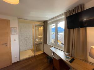 ein Hotelzimmer mit einem großen Fenster und einem Bad in der Unterkunft Pension Klimesch in Mondsee