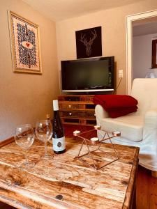 a living room with two wine glasses and a table at Ferienwohnung mit Sauna am Wald - Eifel in Kommern