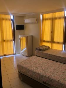 - 2 lits dans une chambre dotée de rideaux jaunes dans l'établissement DİZLEK PANSİYON, à Antalya