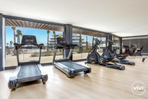 einem Fitnessraum mit drei elliptischen Maschinen in einem Raum in der Unterkunft ViVi Homes - Galatea Pool, Gym, Sauna & Beach in Torremolinos