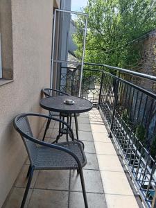 a table and chairs sitting on a balcony at Central Sweet Home I.M. in Novi Sad
