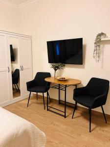 a room with a table and two chairs and a tv at Pop luxury apartments in Belgrade