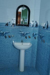 a bathroom with a sink and dolphins in the water at Hotel Theevanni Inn in Trincomalee