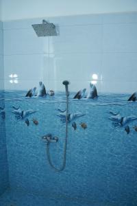 a shower with dolphins swimming in the water at Hotel Theevanni Inn in Trincomalee