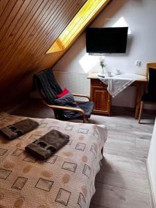 een slaapkamer met een bed, een stoel en een bureau bij Szyper 2 in Jastarnia