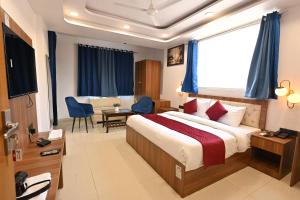Hotel Down Town Paschim Vihar في نيودلهي: غرفة فندقية بسرير وطاولة وكراسي