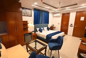 a hotel room with a bed and a tv at Hotel Down Town Paschim Vihar in New Delhi