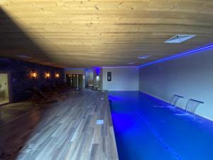 una piscina con iluminación azul en un edificio en What Else Hotel, en Saint-Vulbas
