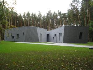 twee grijze modulaire gebouwen met een grasveld bij Twinstone Lodge in Genk