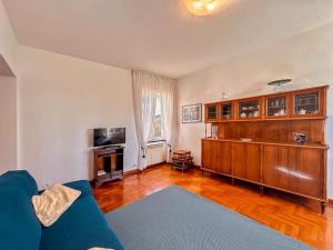 Una sala de estar con un sofá azul y un televisor. en [5Terre]Nel Verde sul Mare - Relax in the Greenery, en Sestri Levante