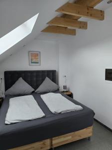 1 dormitorio con 1 cama negra y 2 almohadas en Balthasar Neumann Speiserei & Gästehaus - Zentrum Brühl -, en Brühl