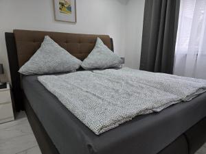 a bed with two pillows on top of it at Balthasar Neumann Speiserei & Gästehaus - Zentrum Brühl -E-Ladestation, nähe Phantasialand in Brühl +112 photos