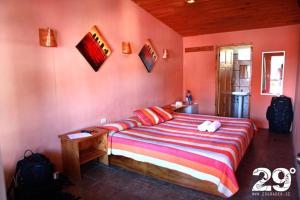 a bedroom with a large bed in a pink wall at Manakin Lodge, Monteverde in Monteverde Costa Rica